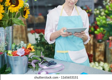 Mid section portrait of unrecognizable florist using digital tablet in shop - Powered by Shutterstock