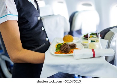 Mid Section View Of An Air Hostess Carrying A Tray Of Food