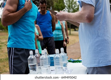 Mid section of volunteer registering athletes name for race in park - Powered by Shutterstock