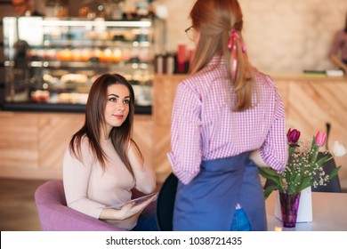 Mid Section Of Waitress Taking Order At Restaurant