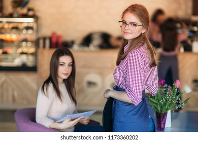 Mid Section Of Waitress Taking Order At Restaurant