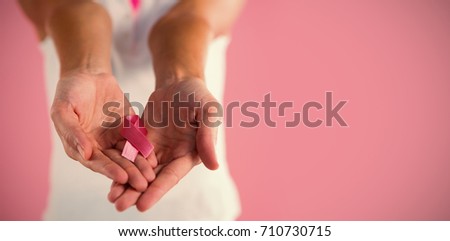 Mid section of woman with pink ribbon breast cancer awareness ribbon