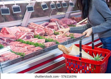 Mid section of woman pointing at meat in display at supermarket - Powered by Shutterstock