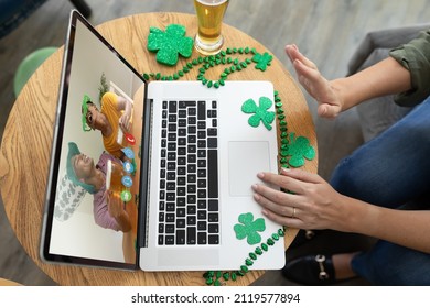 Mid Section Of Woman Waving While Having A Video Conference On Laptop At A Bar. St Patricks Celebration Concept