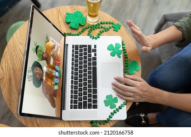 Mid Section Of Woman Waving While Having A Video Conference On Laptop At A Bar. St Patricks Celebration Concept