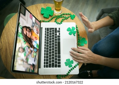 Mid Section Of Woman Waving While Having A Video Conference On Laptop At A Bar. St Patricks Celebration Concept