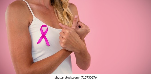 Mid section of young woman with ribbon against pink background - Shutterstock ID 710730676