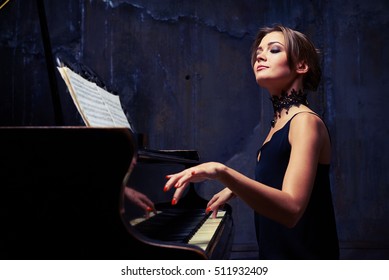 Mid side shot of elegant woman starts piano performance while sitting isolated in studio. She is using sheet music while sitting tall and proud at the piano with shoulders down