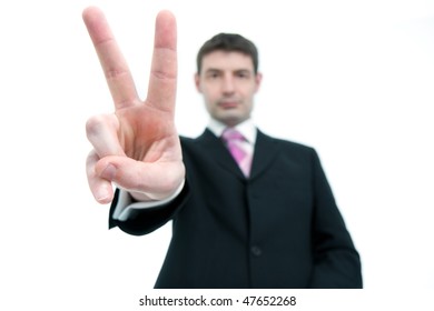 A Mid Thirties Businessman In A Black Suit Holding Up Two Fingers.  Differential Focus On The Hand.