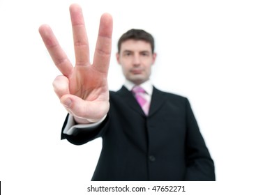 A Mid Thirties Businessman In A Black Suit Holding Up Three Fingers.  Differential Focus On The Hand.