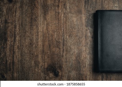 Mid View Of A Closed Bible On A Wooden Texture. Bible Study Desk