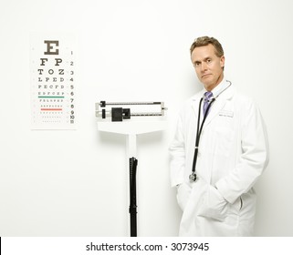 Mid-adult Caucasian Male Doctor Standing Next To Scale With Eye Chart On Wall.