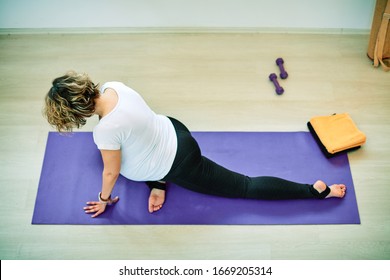 Mid-adult fit pregnan Caucasian woman practicing yoga. Morning time.	