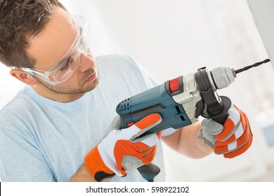 Mid-adult Man Drilling In Wall