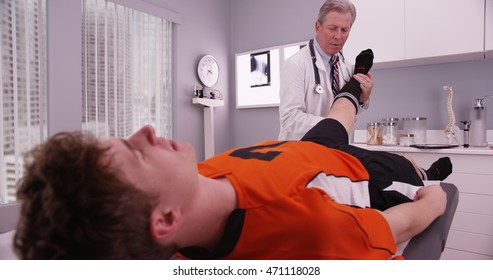 Mid-aged Physical Therapist Examining College Athlete Sports Injury.