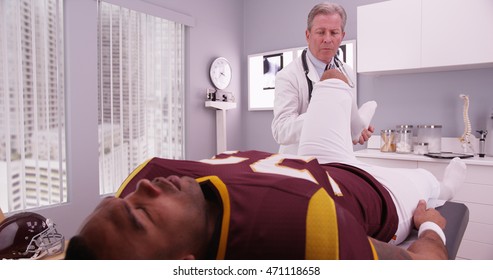 Mid-aged Physical Therapist Examining College Athlete Sports Injury.