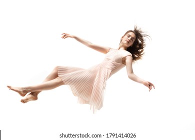 Mid-air beauty cought in moment. Full length shot of attractive young woman hovering in air and keeping eyes closed. Levitating in free falling, lack of gravity. Freedom, emotions, artwork concept.