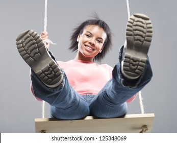 Midair shot of a teenager girl sitting on a swing - Powered by Shutterstock