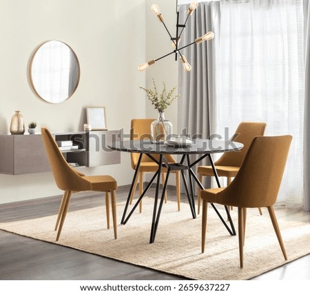 Midcentury inspired dining area featuring mustard upholstered chairs, round black wood table with iron legs, modern brass chandelier, natural morning light and beige curtains over large window