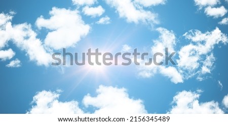 The midday sun is directly overhead, clouds and sun rays.