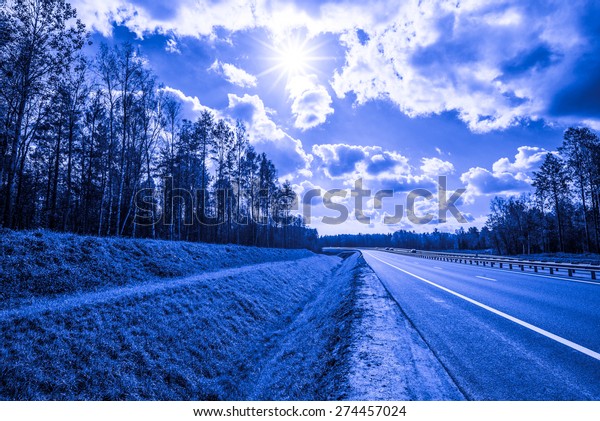 Midday sun on country roads in the forest. Image
in the blue toning