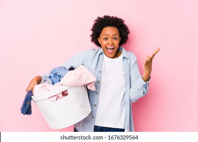 Middle age african american woman doing laundry isolated celebrating a victory or success