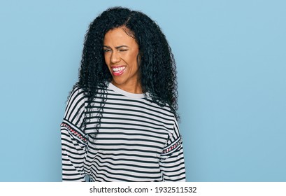 Middle age african american woman wearing casual clothes winking looking at the camera with sexy expression, cheerful and happy face. 