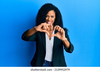 Middle Age African American Woman Wearing Business Clothes Smiling In Love Doing Heart Symbol Shape With Hands. Romantic Concept. 