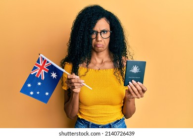 Middle Age African American Woman Holding Australian Flag And Passport Depressed And Worry For Distress, Crying Angry And Afraid. Sad Expression. 