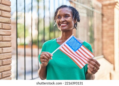 Middle Age African American Woman Smiling Confident Holding United States Flag At Street