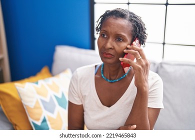 Middle age african american woman talking on smartphone with worried expression at home - Powered by Shutterstock