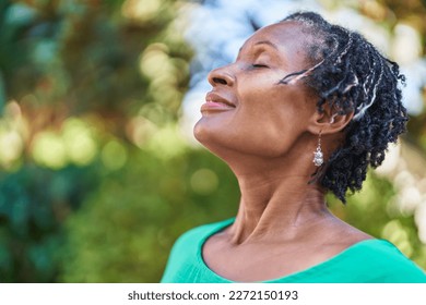 Middle age african american woman smiling confident breathing at park - Powered by Shutterstock