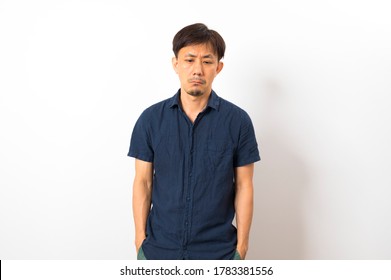 Middle age Asian man with sad depression frustration hopeless expression on white background. - Shutterstock ID 1783381556