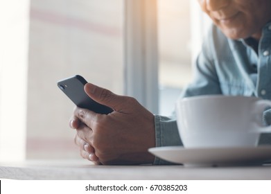 Middle Age Asian People,  30-40s Smiling Casual Man Checking Internet Application On Smart Phone. Man Using Mobile Smart Phone For Social Media Internet Network Or Video Call Communication, Close Up.