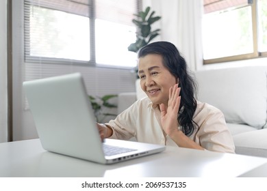 Middle Age Asian Woman Work From Home. Smiling Beautiful Mature asian Woman VDO Call Conference Talk Chat Online On Video Call On Laptop Webcam   With Technology Concept.