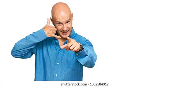Middle Age Bald Man Wearing Casual Clothes Smiling Doing Talking On The Telephone Gesture And Pointing To You. Call Me. 