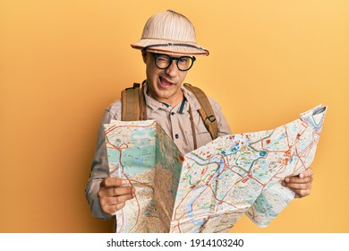 Middle Age Bald Man Wearing Explorer Hat Holding Map Winking Looking At The Camera With Sexy Expression, Cheerful And Happy Face. 