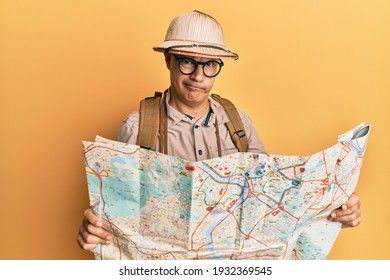 Middle Age Bald Man Wearing Explorer Hat Holding Map Skeptic And Nervous, Frowning Upset Because Of Problem. Negative Person. 