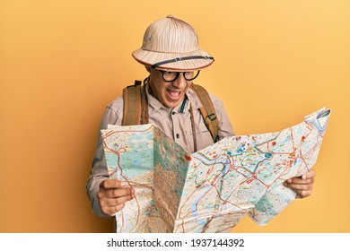 Middle Age Bald Man Wearing Explorer Hat Holding Map Smiling And Laughing Hard Out Loud Because Funny Crazy Joke. 