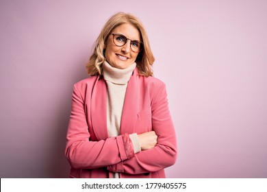 Middle Age Beautiful Blonde Business Woman Wearing Elegant Pink Jacket And Glasses Happy Face Smiling With Crossed Arms Looking At The Camera. Positive Person.