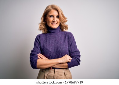 Middle Age Beautiful Blonde Woman Wearing Purple Turtleneck Sweater Over White Background Happy Face Smiling With Crossed Arms Looking At The Camera. Positive Person.