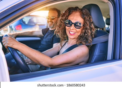 Middle Age Beautiful Couple On Vacation Wearing Sunglasses Smiling Happy Driving Car.