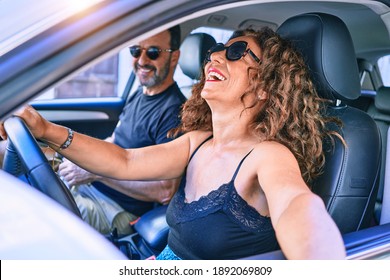 Middle Age Beautiful Couple On Vacation Wearing Sunglasses Smiling Happy Driving Car.