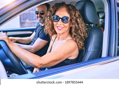 Middle Age Beautiful Couple On Vacation Wearing Sunglasses Smiling Happy Driving Car.