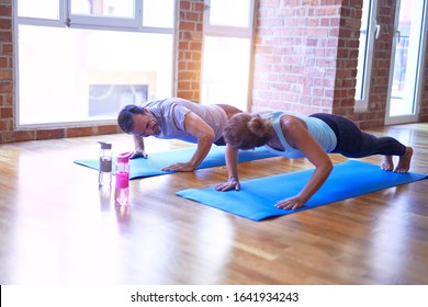 Middle Age Beautiful Sporty Couple Smiling Happy. Practicing Yoga Doing Four-limbed Staff Pose At Gym