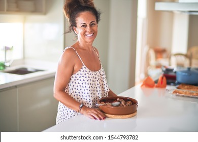 Middle age beautiful woman standing on kitchen cooking and smiling - Shutterstock ID 1544793782