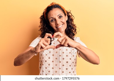 Middle Age Beautiful Woman Wearing Casual T Shirt Smiling In Love Doing Heart Symbol Shape With Hands. Romantic Concept. 