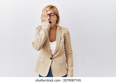 Middle Age Blonde Business Woman Standing Over Isolated Background Yawning Tired Covering Half Face, Eye And Mouth With Hand. Face Hurts In Pain. 