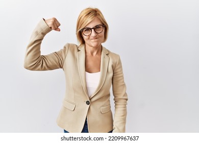 Middle Age Blonde Business Woman Standing Over Isolated Background Strong Person Showing Arm Muscle, Confident And Proud Of Power 