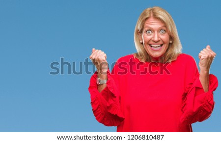 Middle age blonde woman over isolated background celebrating surprised and amazed for success with arms raised and open eyes. Winner concept.
